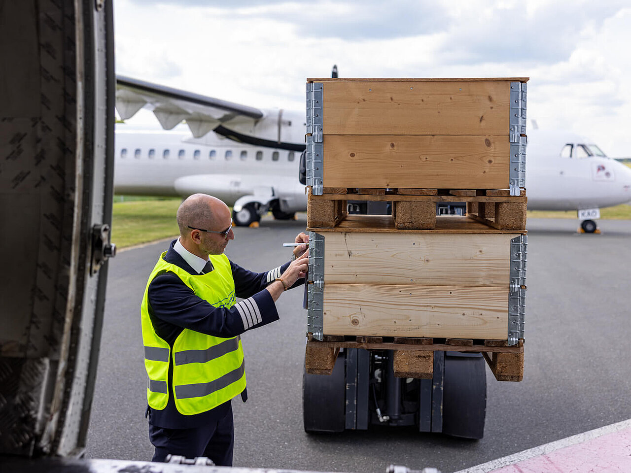 Das Bild zeigt einen Mitarbeiter des Flughafen Hof-Plauen beim beladen einer Transportmaschine